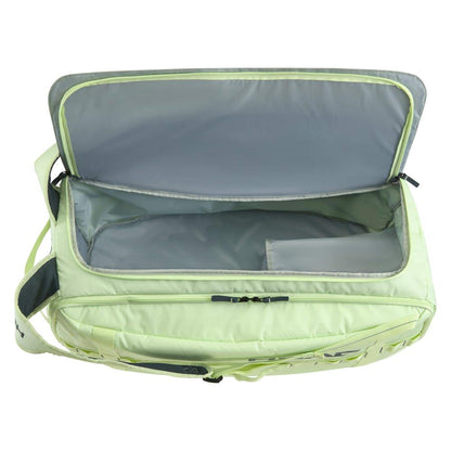 The HEAD Pro Duffle Badminton Bag L - LLAN by HEAD is displayed open on a white background. This roomy light green bag has a gray-lined interior with a small side pocket, and the zipper is undone. It also includes an adjustable shoulder strap on the side for convenient carrying.