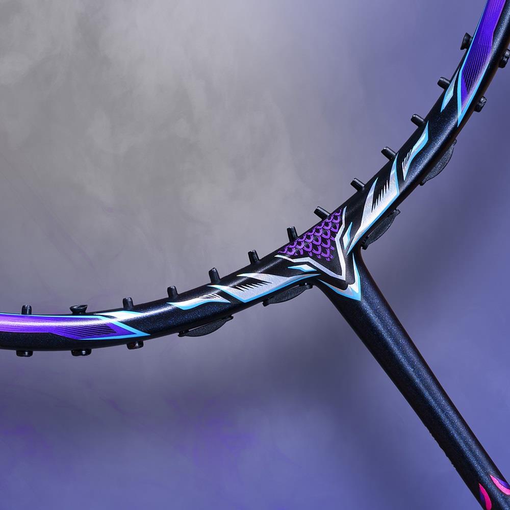 Close-up of a badminton racket's hoop and throat, highlighting a sleek, modern design with purple and blue accents against a foggy purple background. The Victor Thruster Ryuga II Pro 3U Badminton Racket - Mazarine Blue exhibits its HARD CORED TECHNOLOGY, elevating both performance and style.