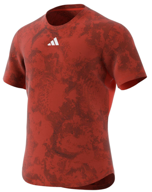 The ADIDAS Paris Men's Freelift Badminton T-Shirt in red, designed by adidas, showcases a subtle marbled pattern and includes a small white logo on the chest. Made using HEAT.RDY technology, the lightweight fabric makes it ideal for sports or casual wear.