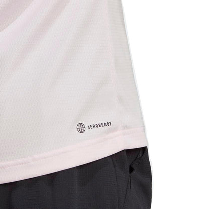 Close-up of a clear pink adidas Melbourne Men’s Raglan T-Shirt made from AEROREADY recycled materials, featuring a subtle logo near the hem. The image also showcases part of black athletic shorts, highlighting their lightweight and breathable fabric, emphasizing sustainable design.