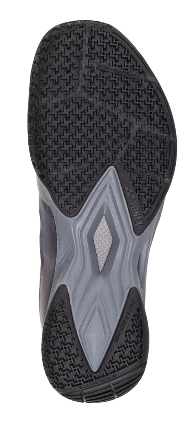 A close-up of the Yonex Power Cushion Aerus Z2 Wide Men's Badminton Shoes in Dark Grey showcases a textured black rubber sole with gray accents and geometric designs, incorporating Yonex's Power Cushion technology for improved comfort.