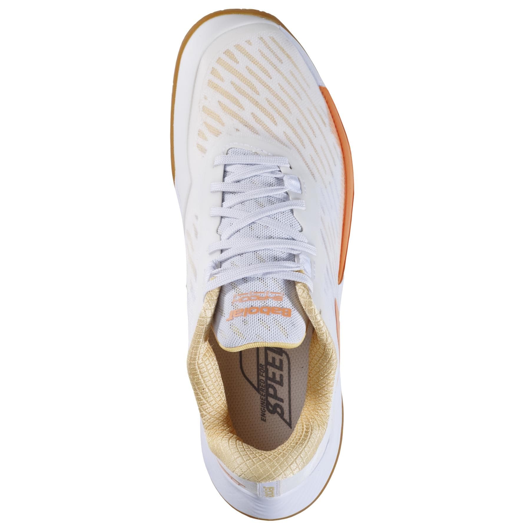 Top view of the Babolat Shadow Tour 5 Women's Badminton Shoe in white and yellow. This lightweight shoe showcases a textured body, lace-up design, and a tan interior with the word "Speed" visible on the inner sole.