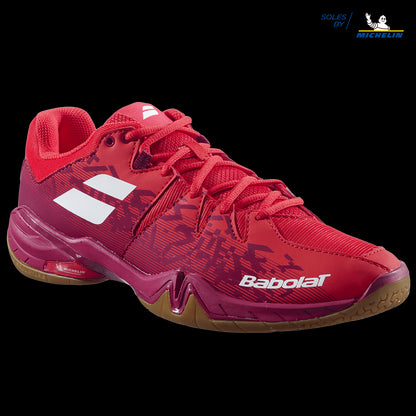 The Babolat Shadow Spirit Men's Badminton Shoes in Cherry Tomato, featuring white and orange accents, include a Michelin rubber grip sole. Designed for athletic performance, these shoes boast a textured pattern and a gum sole.