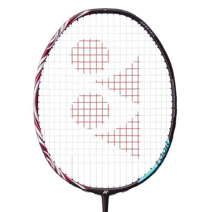 Close-up of a Yonex Astrox 100 Tour 3U Kurenai badminton racket in red, highlighting its black frame complemented by a red pattern on the strings. Designed with a head-heavy balance, this racket is perfect for offensive play, and features an appealing red and white design along the sides.