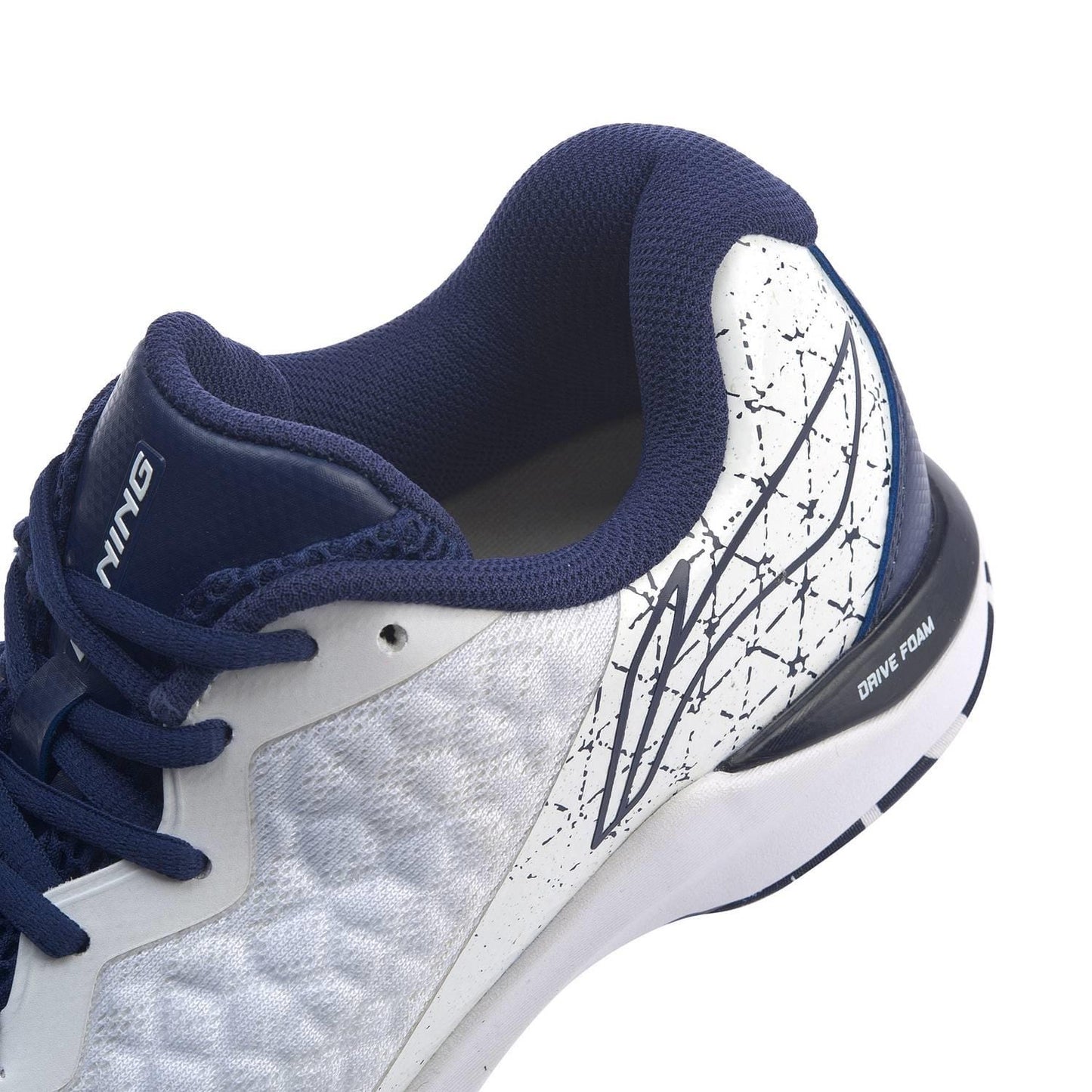 Close-up of the Li-Ning Dagger II SE Mens Badminton Shoe, showcasing its textured white upper, navy blue laces, and navy blue collar. The design includes abstract lines and "Drive Foam" inscribed on the sole, complemented by TUFF-TIP accents for enhanced durability.