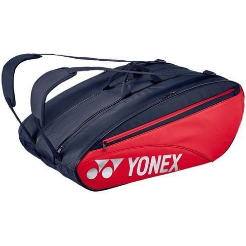 The Yonex 423212EX 12 Piece Racket Bag in scarlet features a stylish black and red design with plenty of storage space and a comfortable shoulder strap, prominently showcasing the classic white Yonex logo.