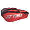 The Yonex 6 Piece Pro Badminton Racket Bag 92226 in Tango Red, featuring a white logo and black accents, is displayed against a simple backdrop. Crafted for versatility, this stylish bag includes multiple compartments and a convenient shoulder strap for easy transport.