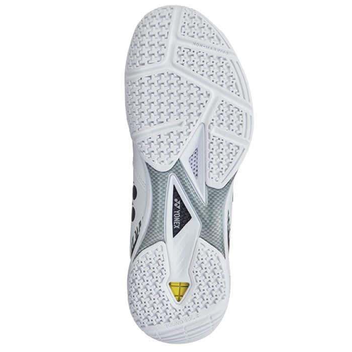 The image displays the sole of a Yonex Power Cushion 65Z3 Men's Badminton Shoe in White Tiger. It features a textured pattern with various geometric shapes, grooves, and a central mesh-like section where the word "POWER" is visible. This limited edition shoe also includes a small yellow detail near the heel.