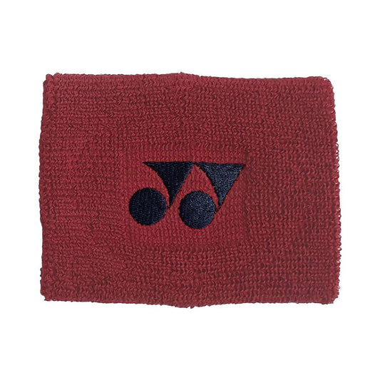 The Yonex AC46088 Sweat Wristband in dark red features absorbent cotton with a textured fabric and a black, stylized embroidered logo depicting two linked circles and a triangle.