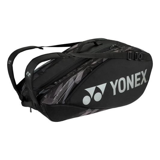 The Yonex 9 Piece Pro Badminton Racket Bag 92229 in black is an ideal choice for carrying racquets and badminton accessories. It elegantly displays the Yonex logo and name on the side, and it features multiple zippers and adjustable straps for both convenience and style.