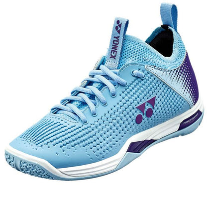 The Yonex Power Cushion Eclipsion Z2 Women's Badminton Shoes in light blue feature a textured surface and a stability-focused design, complemented by a white sole and purple accents. With their low-cut silhouette, heel pull tab, and prominent branding on the tongue and side, they deliver both style and performance.