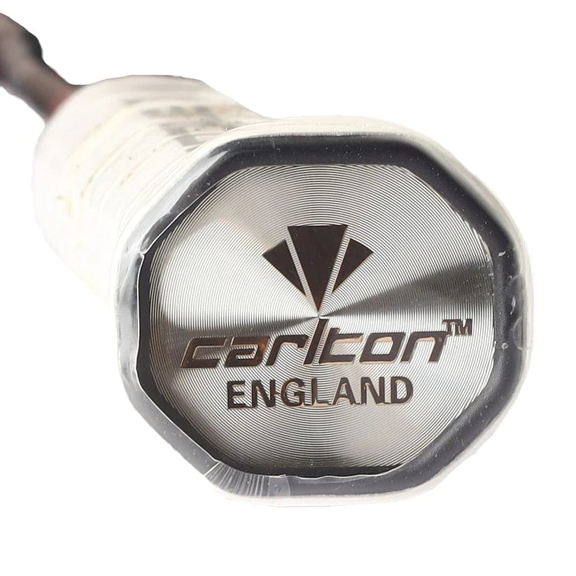 Close-up of the end cap of a Carlton Kinesis Ultra S-Tour badminton racket handle, showcasing a silver metallic surface with "Carlton" and "England" etched prominently. Above, a geometric logo references its Vortex Geometry design, enhancing precision and playability with every swing.