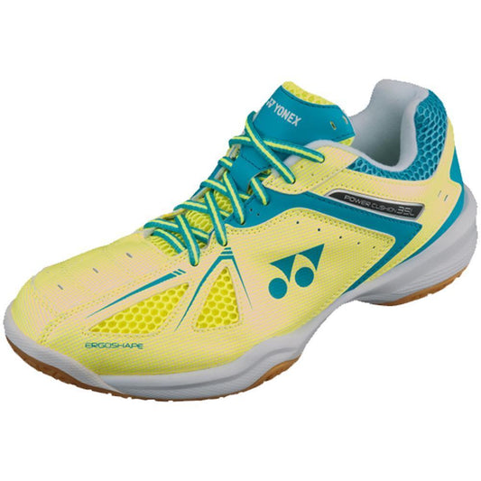 The Yonex Power Cushion 35 Women's Badminton Shoes in Yellow and Sax Blue are vibrant footwear featuring a striking blue geometric design on the heel and a sleek white sole. Designed for superior court grip, these shoes are adorned with teal laces, accents, and the Yonex logo with text on the side for an extra touch of style.