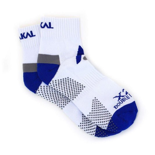 A pair of Karakal X2+ men's technical ankle badminton socks in white with navy accents, featuring a pattern of small dots. These anti-slip socks have the brand name "Karakal" printed near the top and along the sides.