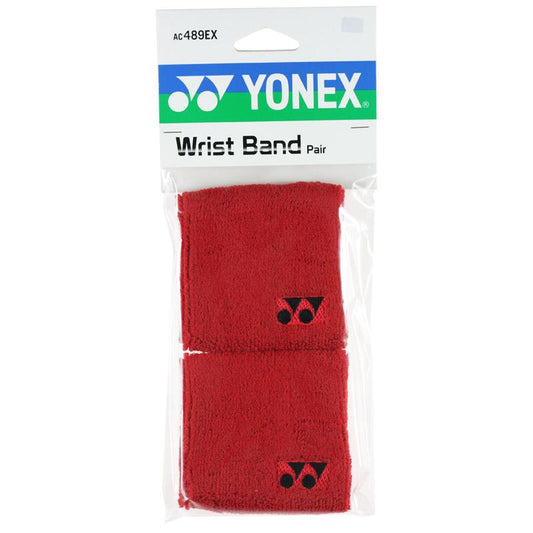 A pair of Yonex AC489EX Badminton Sweat Wristbands in red comes in clear plastic packaging with a green and blue top section displaying the Yonex logo and product code. Each soft, sweat-absorbing wristband features a small black Yonex logo.