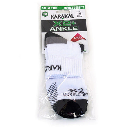 The Karakal X2+ Mens Technical Ankle Badminton Socks in a striking white and black design, available in UK sizes 7 to 13, showcase "Double Density" and "Lycra" for optimal shock absorption. Packaged in transparent plastic, these socks by Karakal come with additional product details on the label.