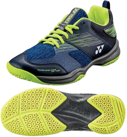 Introducing the Yonex Power Cushion 37 Men's Badminton Shoes in navy blue and yellow, featuring the renowned Yonex Power Cushion technology for exceptional comfort. The yellow laces complement the treaded sole, designed with a hexagonal pattern for enhanced grip. The iconic brand logo is prominently displayed on both the side and tongue of the shoe.