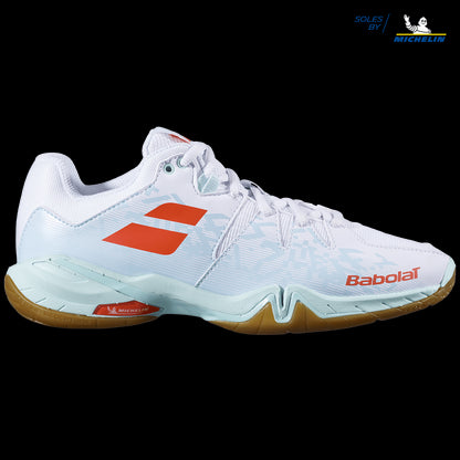 Introducing the Babolat Shadow Spirit Women's Badminton Shoes in White and Light Blue, featuring vibrant orange accents against a black backdrop. Designed for optimal sports performance, these shoes showcase the renowned Babolat branding and come equipped with Michelin grip soles, making them perfect for badminton enthusiasts.