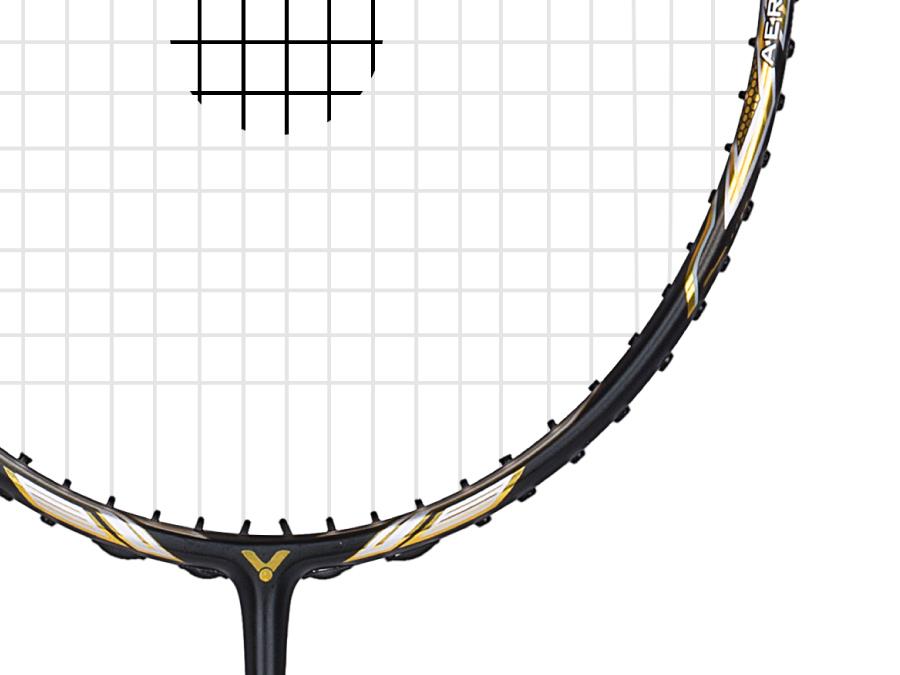 A close-up of the Victor Jetspeed S10C Badminton Racket - Black Gold reveals its intricate string pattern and sleek Japanese carbon fiber frame. The black frame, adorned with gold and white accents, exemplifies the precision and elegance characteristic of high-performance badminton equipment from Victor.