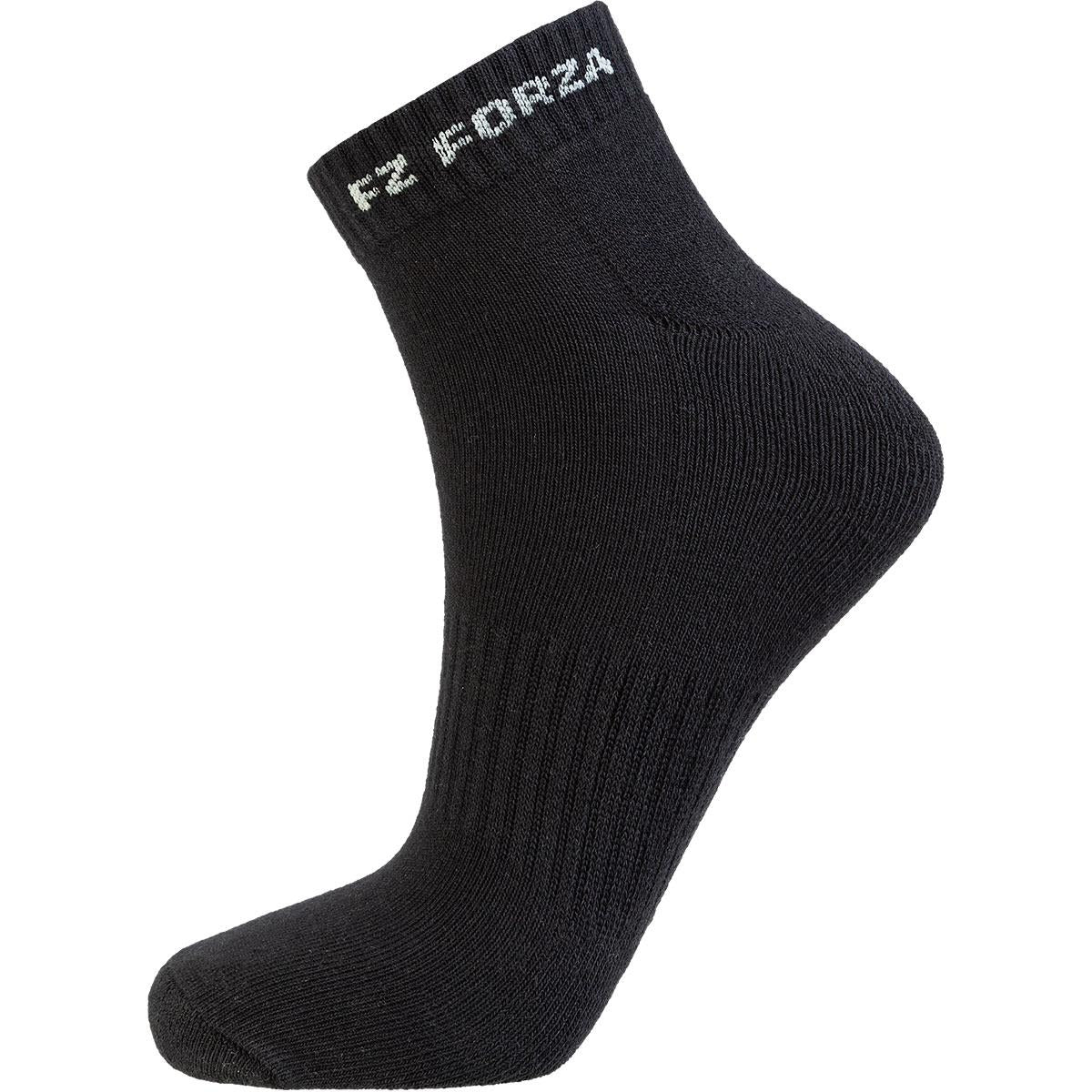 The FZ Forza Comfort Short Black Badminton Socks feature a ribbed texture and the text "FZ FORZA" in white near the cuff. They are showcased elevated on an invisible foot model, emphasizing their shape, fit, and comfort for every game.