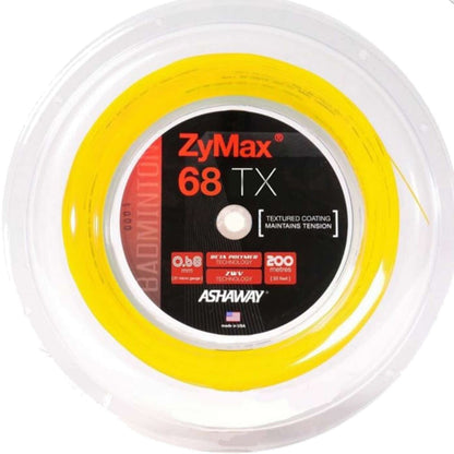 A spool of Ashaway Zymax 68 TX Badminton String in yellow, designed with advanced ZyWeave technology, is displayed. It comes in a transparent plastic case and features a black and red label that emphasizes its textured surface and substantial 200-meter length.