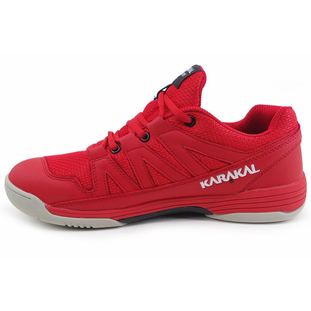 Introducing the Karakal KF Pro Lite Men's Badminton Shoe in red: an athletic marvel featuring "Karakal" prominently on the side. Engineered for performance, it includes a mesh and synthetic upper, lace-up closure, and a non-marking outsole for enhanced lateral stability, complemented by decorative stitching and textured patterns.