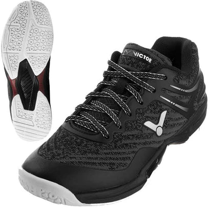 Introducing the VICTOR A922 Black Badminton Shoes: These athletic shoes showcase a sleek black and gray color scheme with a contrasting white sole. The design is textured, and the "Victor" logo prominently adorns the tongue. Equipped with black and white laces and EnergyMax 3.0 cushioning, these shoes offer exceptional comfort. An additional image highlights the unique tread pattern on the sole, perfect for badminton players seeking style and performance.