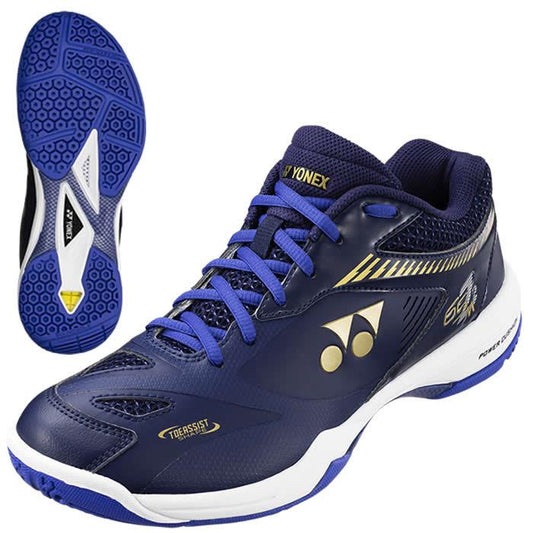 The Yonex Power Cushion 65Z2 Men's Badminton Shoes in Sapphire Navy exhibit a sleek design with a textured sole for enhanced grip. They include gold and white accents, a lace-up closure, and prominently display the Yonex logo. Inspired by Kento Momota's style, the shoe's detailed sole pattern is remarkable in close-up views.