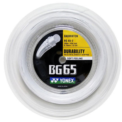 A close-up of the Yonex BG 65 Badminton String Reel in white showcases its multifilament core and nylon fibers designed for enhanced durability. The label states that it is 200m (656 feet) long and 0.70mm (22 GA) thick, ensuring a soft feel and long-lasting performance, crafted with quality in Japan.