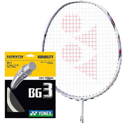 A Yonex BG 3 Badminton String White - 0.74mm, in a 10m packet, is displayed next to a badminton racket. The red stringing features Yonex's logo and highlights characteristics such as high durability and a multifilament core for a soft feeling, made with high-quality nylon fibers.