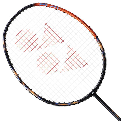 The Yonex Astrox 77 Play 4U High Orange badminton racket boasts a sleek black frame accented with vibrant orange details. Constructed from graphite and featuring ISOMETRIC technology, its white strings showcase a distinctive red triangular pattern against a plain white background, creating a striking visual contrast.