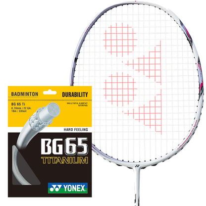 The Yonex BG 65 Ti badminton string in a white, 0.7mm, 10m packet is showcased next to a racket with the Yonex logo prominently featured on its strings. The packaging highlights the string's durability and hard feel, attributed to its multifilament core and premium nylon fibers.