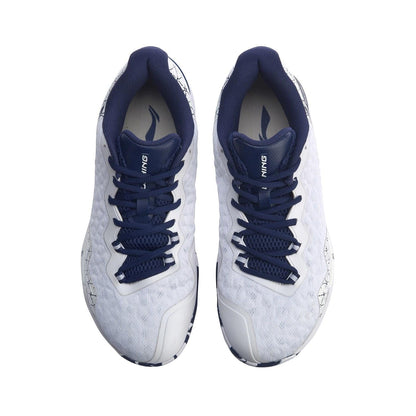 A pair of Li-Ning Dagger II SE men's badminton shoes in white, with dark blue laces and interior, viewed from above. These shoes boast a textured pattern on the surface and feature brand markings on the tongue.