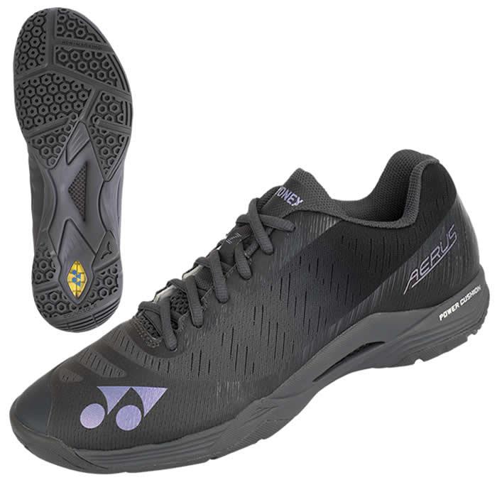 The Yonex Power Cushion Aerus Z Men's Badminton Shoes in dark grey are athletic sneakers featuring a sleek design with branded logos prominently displayed on the side and top. They have a textured sole with a unique pattern, providing excellent grip and support for badminton activities. The shoes are shown from both side and bottom views.