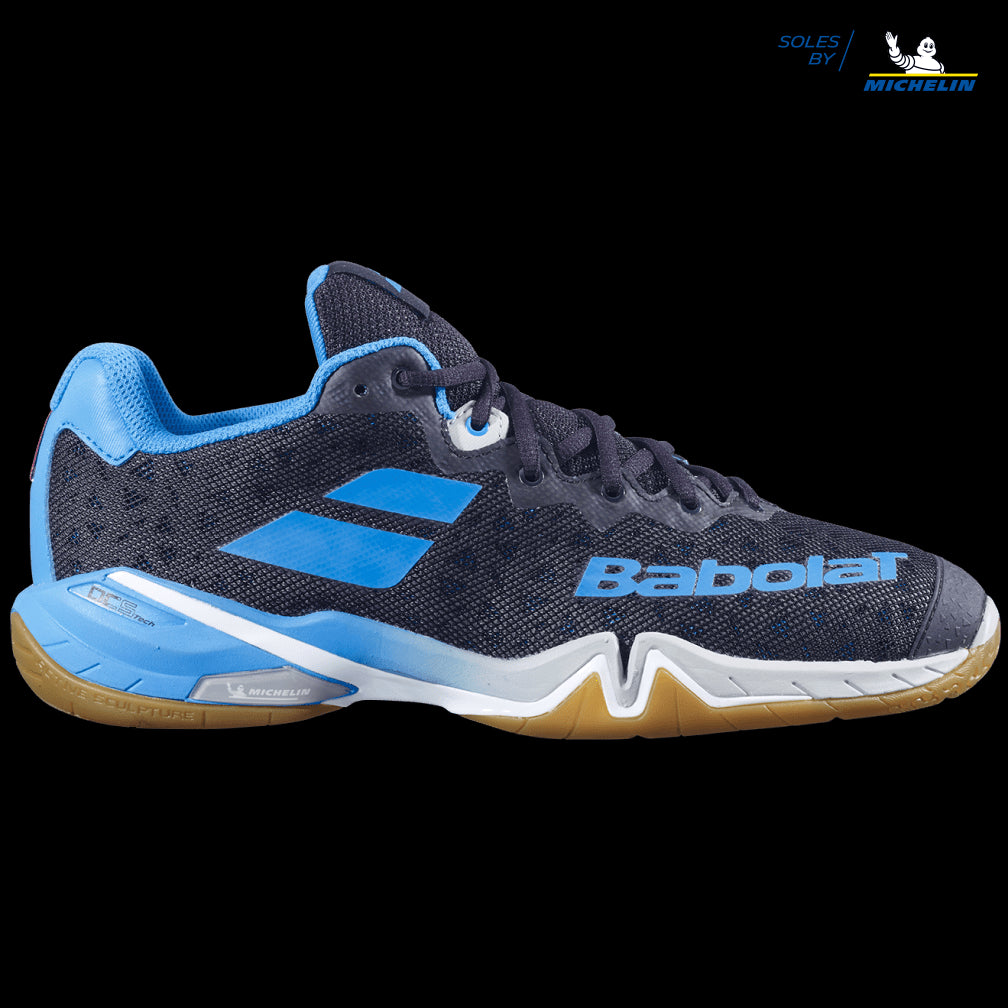 The Babolat Shadow Tour badminton shoe, in stunning black and light blue with a gum sole, showcases dynamic response and light blue accents alongside the Michelin logo. Its textured mesh design and low-cut profile highlight the brand's partnership with Michelin for superior shock absorption technology.