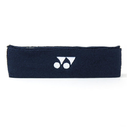 The Yonex AC258 Head Band in Navy Blue features a white logo with two stylized shapes and circles prominently displayed on the front. Ideal for on-court performance, its material feels soft and textured, providing outstanding sweat-absorbing properties.