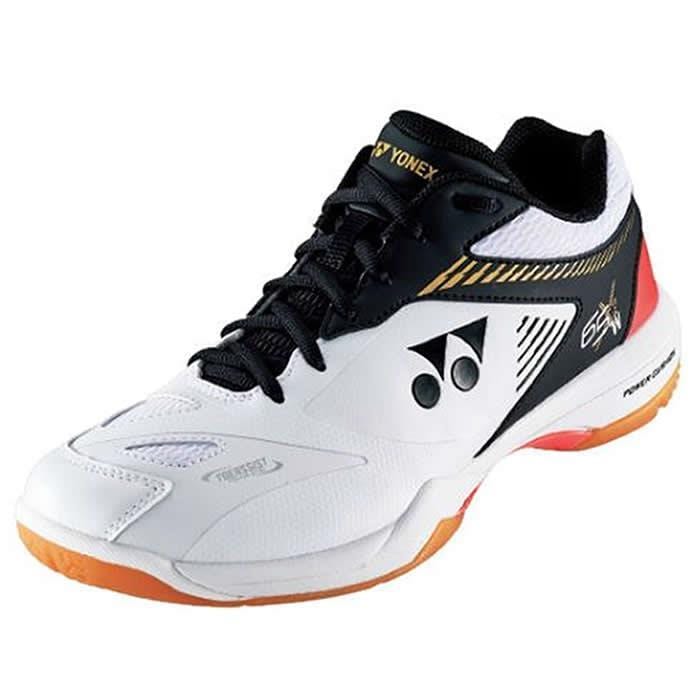 The Yonex Power Cushion 65 X 2 Wide Badminton Shoes in White/Orange combine a striking white and black design with orange accents and a distinctive logo on the side. These high-performance shoes are crafted for athletic excellence, featuring a wide fit, black laces, and a textured sole.