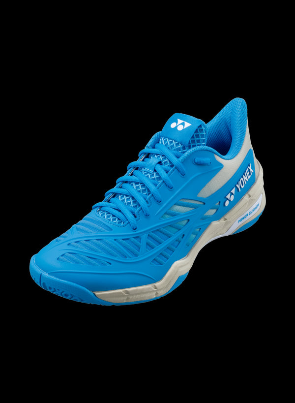 The Yonex Power Cushion Cascade Drive Badminton Shoes in Ocean Blue showcase a sleek design with white accents and perforations for enhanced breathability. The Yonex logo and brand name are prominently displayed on the side, promising exceptional shock absorption. Set against a black background, these shoes stand out beautifully.