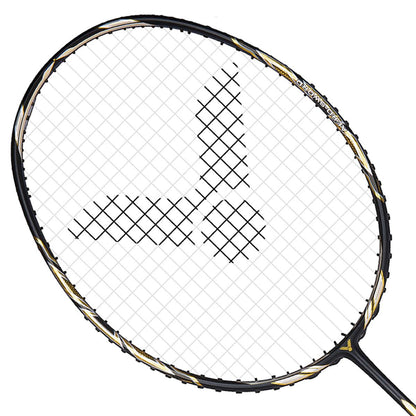 Close-up of the Victor Jetspeed S10C Badminton Racket - Black Gold, showcasing its sleek black and gold design on the frame, crafted with premium Japanese carbon fiber. It features a checkered string pattern that forms an eye-catching stylized logo in the center, all set against a plain white background.