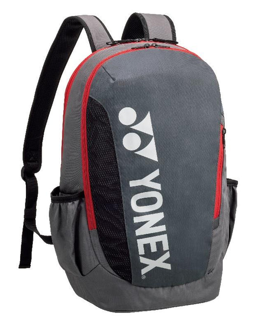 The Yonex Team Badminton Backpack 42112S LTD - Greyish Pearl is a durable backpack featuring a gray and black design with red zippers and the white Yonex logo. It includes adjustable shoulder straps, side pockets, and a convenient shoe compartment, making it ideal for carrying sports equipment or personal items.