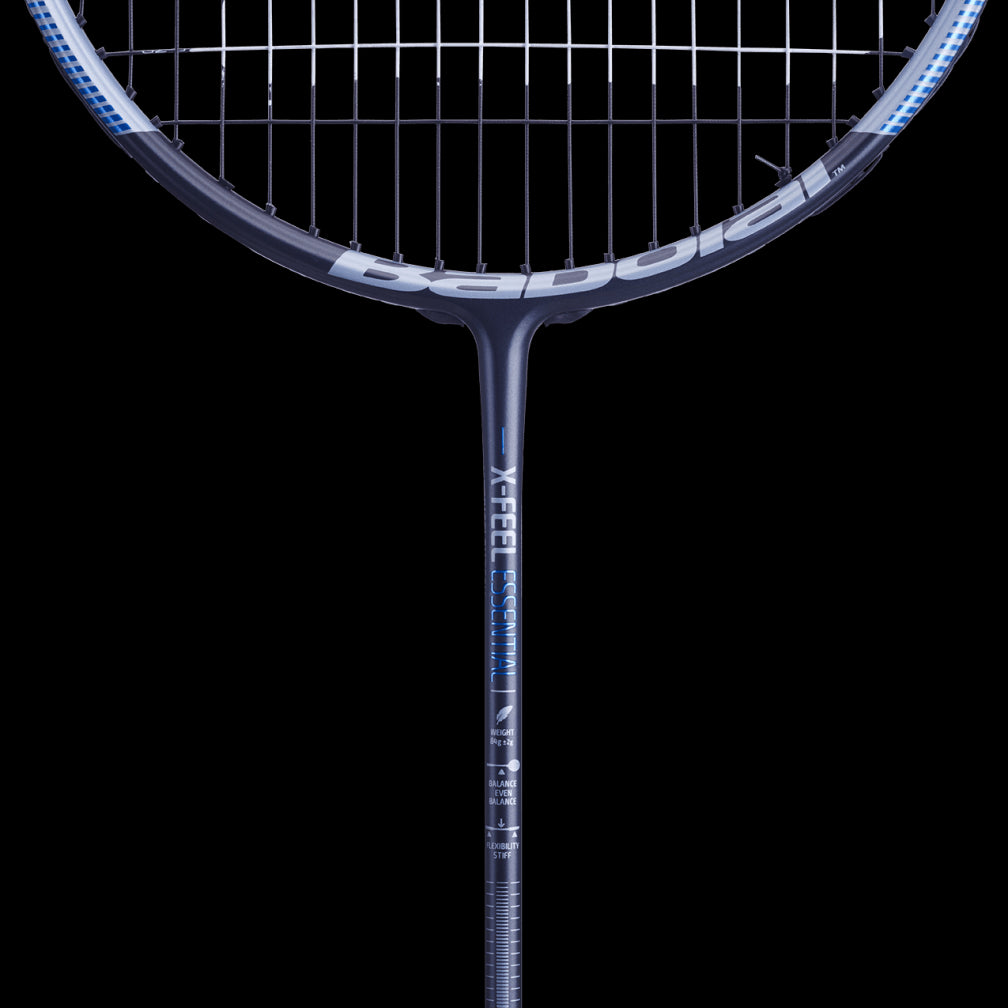 Close-up view of a blue-grey Babolat X-Feel Essential badminton racket set against a black background. The strings and shaft, crafted with Metric Flex technology for improved durability, are visible, and the Babolat brand name appears subtly on the shaft.