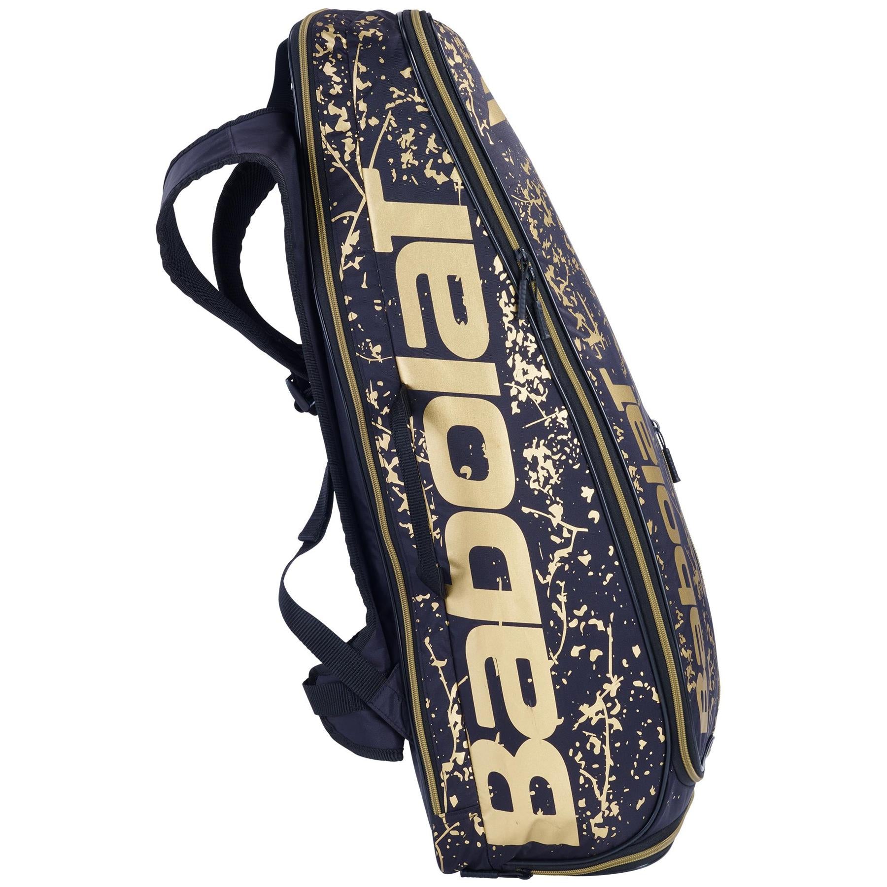 The Babolat Backraq X-Feel LTD Edition Badminton Bag - Goldmine showcases large printed logos and a stylish splatter design in navy and gold. Constructed from recycled PET, it features shoulder straps for convenient carrying along with multiple zippered compartments to keep all your badminton equipment safe.