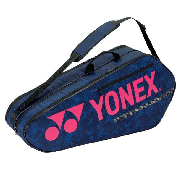 The Yonex 42126EX Team 6 Piece Badminton Racket Bag in navy with a pink accent is equipped with padded shoulder straps and zippers. This vital accessory from Yonex is crafted to securely and comfortably store multiple rackets, ensuring you are always prepared for the game.