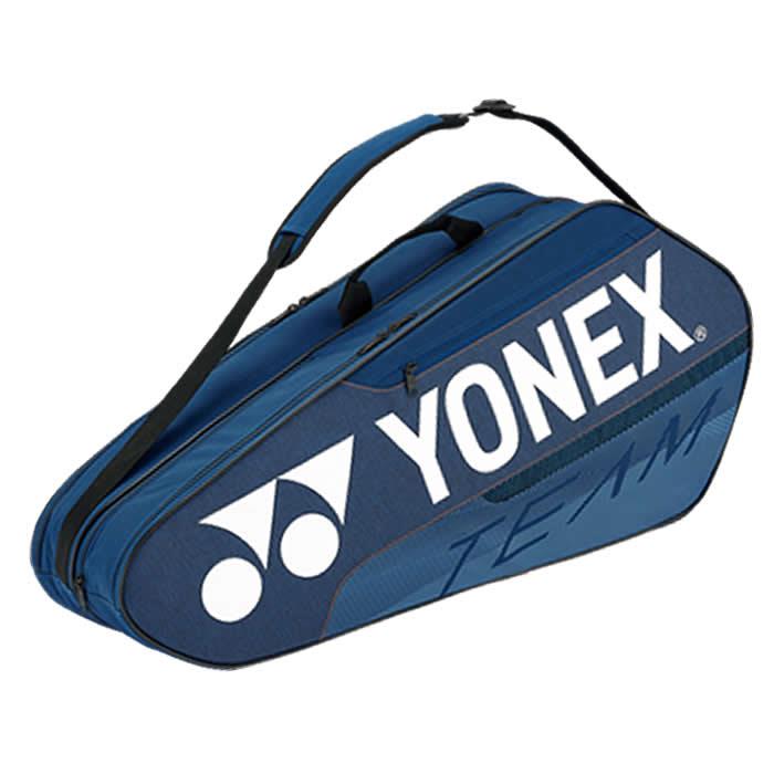 The Yonex 42126EX Team 6 Piece Badminton Racket Bag in Deep Blue showcases a prominent white Yonex logo alongside the word "TEAM" in contrasting text. It is designed with ample storage compartments and includes a shoulder strap, making it spacious enough for carrying multiple rackets and equipment.