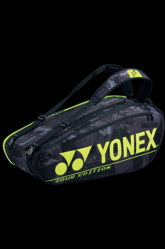 The Yonex 92029EX Pro 9 Piece Badminton Racket Bag - Black Yellow by Yonex boasts a sleek black design accented with neon yellow details and a logo. With its angular appearance and two shoulder straps, this bag is perfect for carrying tennis equipment, featuring isothermal material to protect your gear.