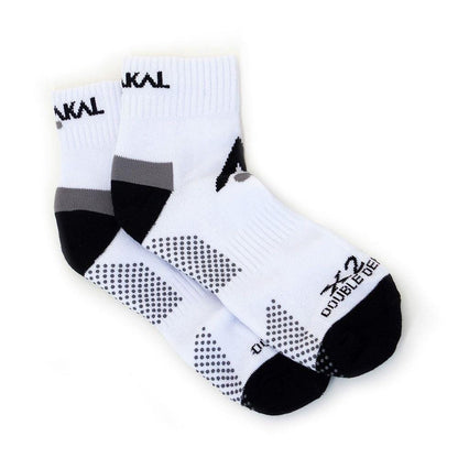 Karakal X2+ Men's Technical Ankle Badminton Socks in white and black, featuring gray accents and anti-slip textured grip patterns. These shock-absorbing socks come with Karakal branding on the ankles and soles, available in sizes UK7-UK13.