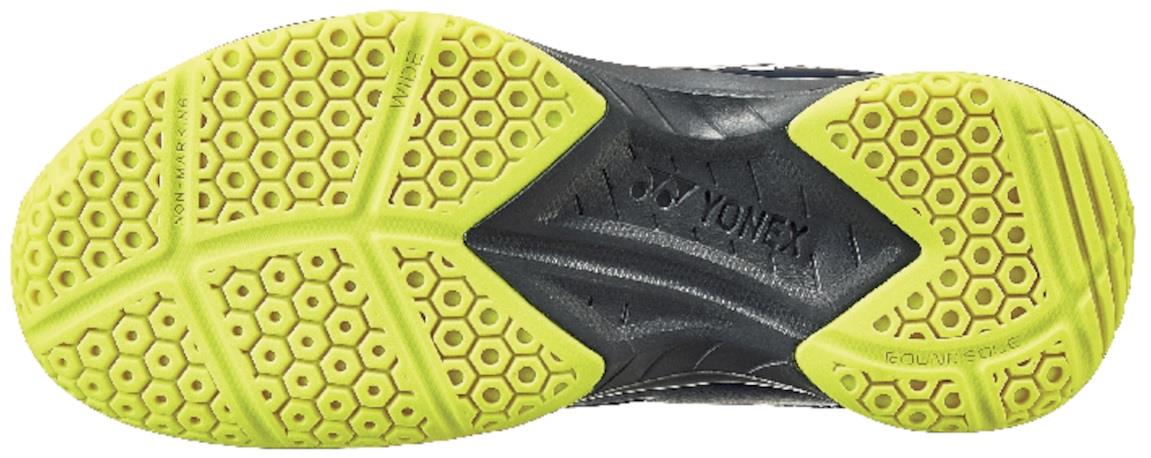 A close-up of the Yonex Power Cushion 37 Mens Badminton Shoes sole reveals a dynamic yellow honeycomb pattern designed for traction, with a dark, textured central section that prominently displays the Yonex brand name.