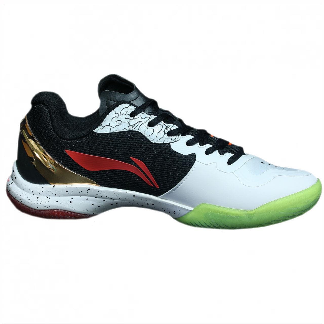 Introducing the Li-Ning Monkey King Limited Edition Badminton Shoe, a stylish choice for athletes with its striking white, black, and red color palette. This shoe features a unique red logo, a black lace area, gold detailing, and a green outsole complemented by speckled white and black accents on the sole.