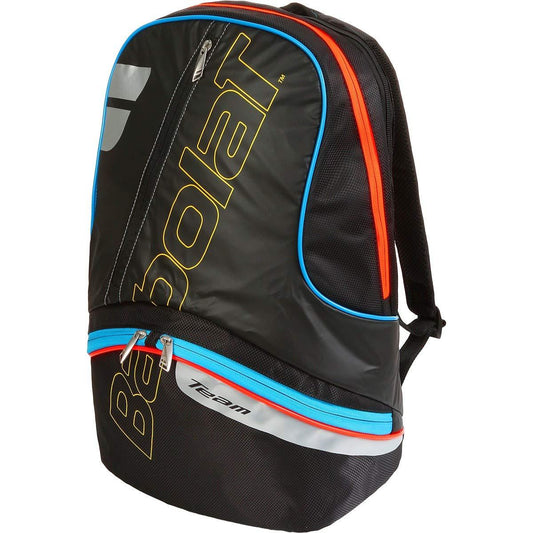 The Babolat Team Black Multicolour Backpack features prominent "Babolat" lettering in bold yellow and red, accented with blue and orange details. It includes specific accessory pockets for organized storage and a zippered compartment for efficient racket transport, with the word "team" stylishly printed near the bottom.