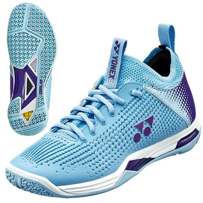 The Yonex Power Cushion Eclipsion Z2 Women's Badminton Shoes in light blue, highlighted with purple and white accents, boast a textured surface and incorporate the Yonex Power Cushion technology for enhanced stability and support. Featuring side and sole views, these shoes display the brand logo along with a patterned grip design.